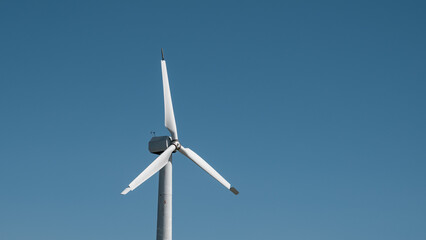 A wind turbine is standing tall in the sky