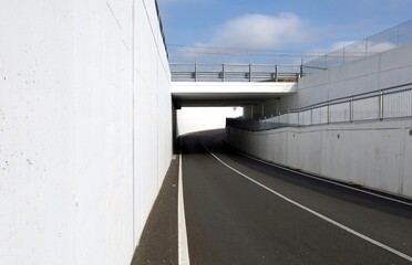White concrete wall surrounding the underpass before the the road bridge. Background for copy space.