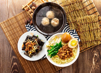 Dry noodles with Black Fungus, meatballs soup, minced pork meat and preserved egg with chopsticks served in dish isolated on napkin top view on table taiwan food