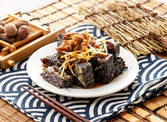Duck rice blood cube with minced pork, ginger and chopsticks served in dish isolated on napkin side view on table taiwan food