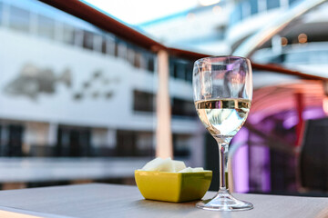 Glass of white wine cafe and fruit light snack on table in sunlight. Atmosphere of delightful event and romantic summer
