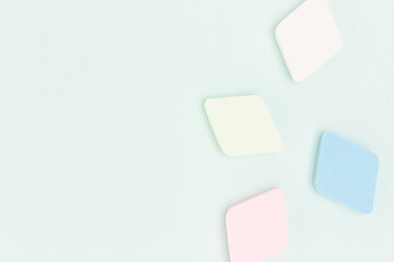 Multicolored makeup sponges scattered on a blue pastel background. Copy space.