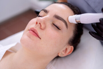  Young beautiful woman getting lifting anti-aging, face massage a