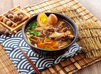 Pork Ribs Crispy Noodles soup with preserved egg, chopsticks served in dish isolated on napkin side view on table taiwan food