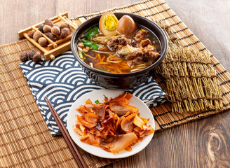 Spare ribs noodle set with pig scalp, preserved egg, chopsticks served in dish isolated on napkin side view on table taiwan food