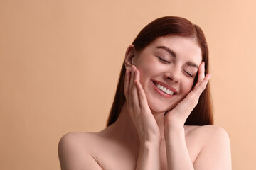 Portrait of smiling woman on beige background. Space for text