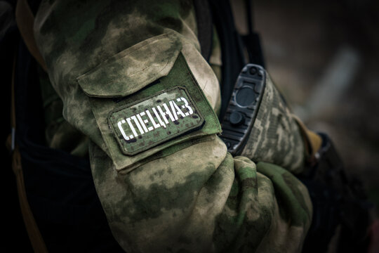 A special forces soldier with a machine gun in close-up. translation of the inscription on the patch on the sleeve of the uniform is special forces.