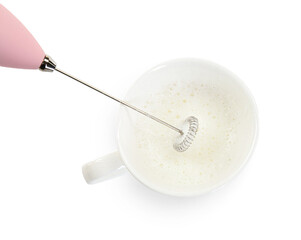 Whisking milk in cup with mini mixer (frother wand) isolated on white, top view