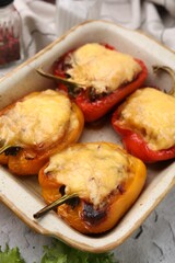 Delicious stuffed bell peppers in baking dish on table