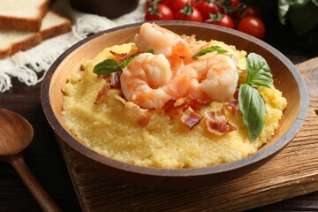 Fresh tasty shrimps, bacon, grits and basil in bowl on table, closeup