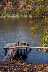 a small wooden pier on the riverbank in the fall forest