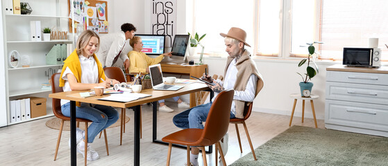 Team of graphic designers working at table in office