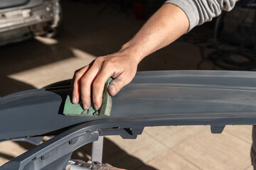 Detail of Mechanic Hand Sanding Car Bumper