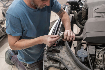 Auto Mechanic Installing Radiator Hose in Workshop
