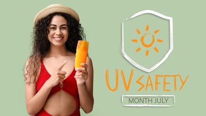 Beautiful young African-American woman with sunscreen cream and text UV SAFETY MONTH - JULY on...