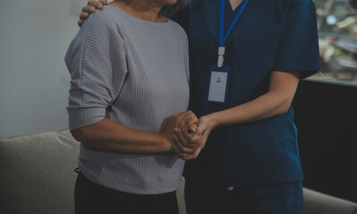 Female caregiver doing regular check-up of senior woman in her home.