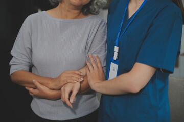 Female caregiver doing regular check-up of senior woman in her home.