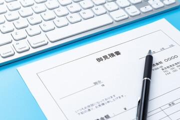 青背景にキーボードと見積書