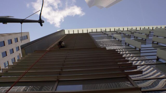 A window washer works on a sunny day