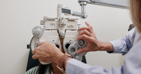 Eye care, medical and child in clinic, test and hand of specialist, phoropter or refractor for...