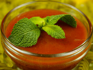 Glass bowl with tomato sauce and  mint leaves for paste, background