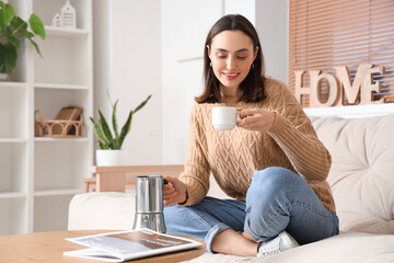 Pretty young woman with geyser coffee maker drinking espresso in living room