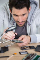 repairman disassembling smartphone with tweezers