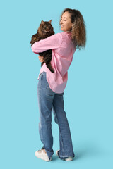 Mature woman with cute cat on blue background