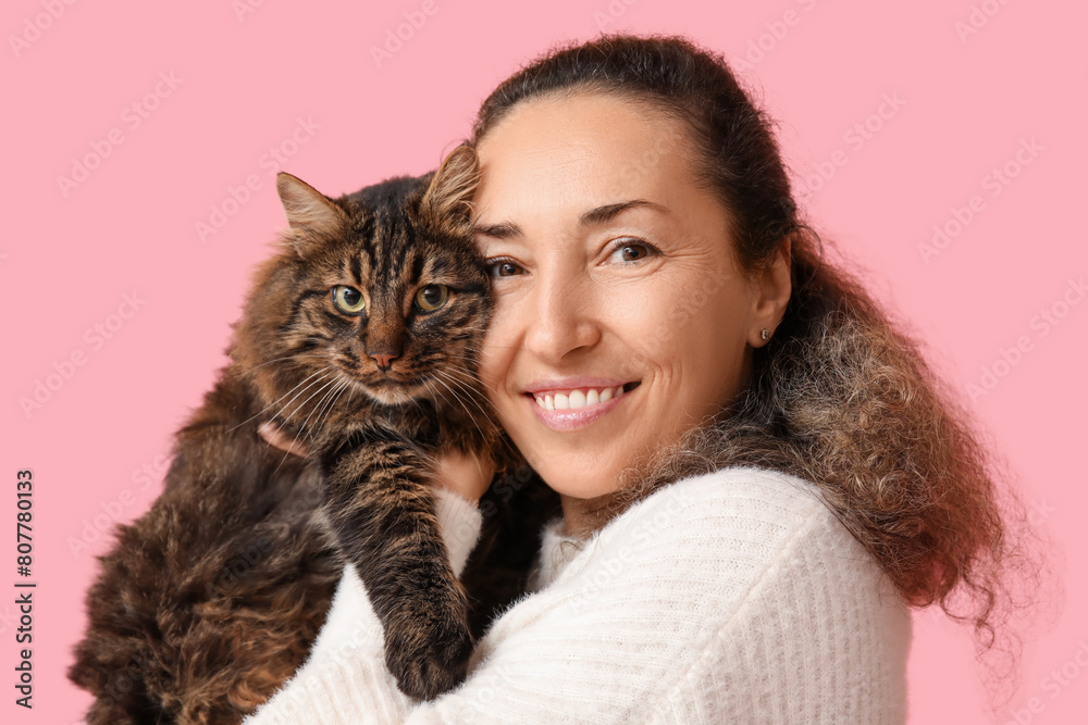 Wall mural Mature woman with cute cat on pink background