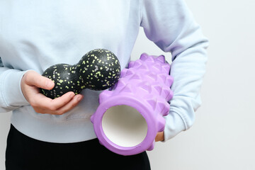 Female hands hold a massage foam body massage rollers. Foam rollers for massage of muscle and fascia.