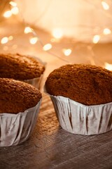 Freshly made homemade cupcakes up close with lights in the background.