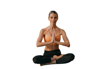 Contented young adult caucasian woman in sportswear sitting on yoga mat in lotus pose with folded hands in prayer gesture looks at camera outdoors. Meditation at nature, mental health.