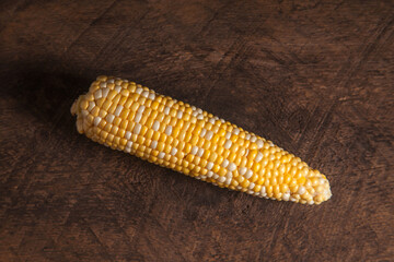 Cob sweet corn on wooden background..