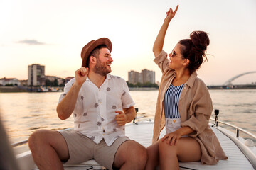 Couple having fun singing and dancing while sailing on a boat