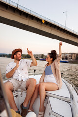 Couple singing and dancing while sailing on a boat