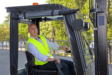 Bald Driver With Yellow Safety Vest in Forklift Cabin