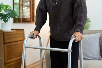 A person is holding a walker with a hand on the handle. healthcare concept