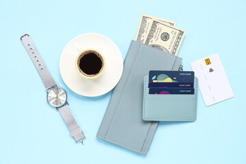Composition with blue credit holder, cards, wallet, cup of coffee and money on blue background, closeup
