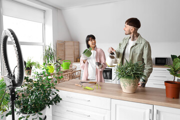 Couple of bloggers with plants and gardening tools recording video at home