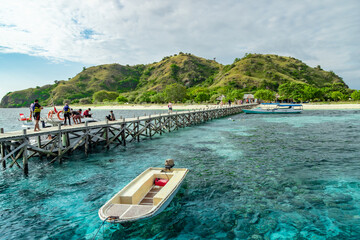 Welcome to Kanawa Island in Labuan Bajo, Indonesia, where boats dock at the pier, inviting you to...