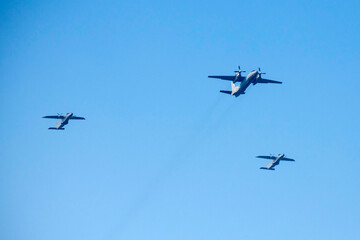 Propeller airplane are flying as a v formation on isolated blue sky