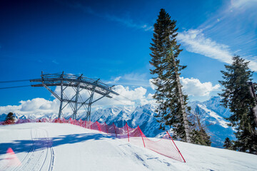 Ski slopes with cable car tracks and a metal support from a freeride track with untouched snow...