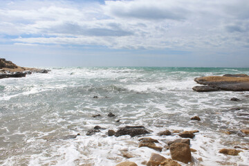 natural background of sea sky and stones, beautiful view of Mediterranean coast in Spain, waves in the sea