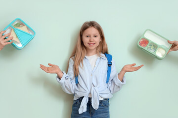 Happy girl and hands with school lunchboxes on turquoise background