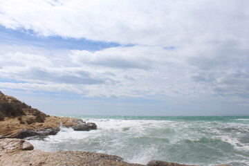 natural background of sea sky and stones, beautiful view of Mediterranean coast in Spain, waves in the sea