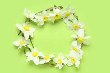 Frame made of daffodil flowers on green background. Top view