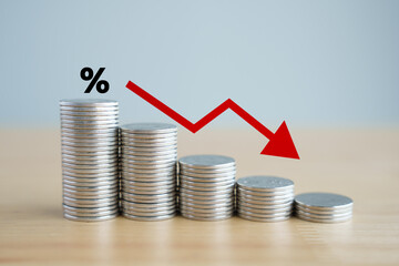 Interest rate finance and mortgage rates. Percentage sign on stack of coins and arrow down,...