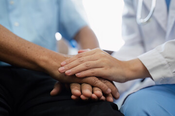 Doctors or nurses hold hands of elderly patients to support and soothe