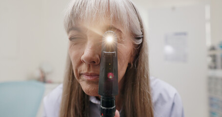 Optometrist, light and ophthalmoscope in clinic for eye exam, eye care and vision. Specialist,...