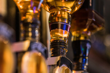 Close-up of illuminated beer taps at a bar